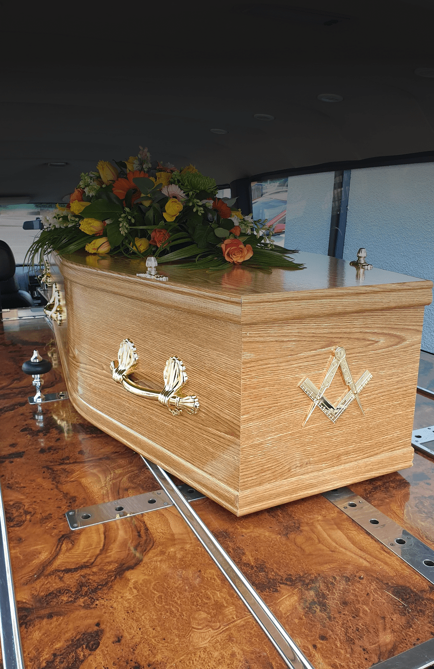 Floral-decorated coffin in hearse
