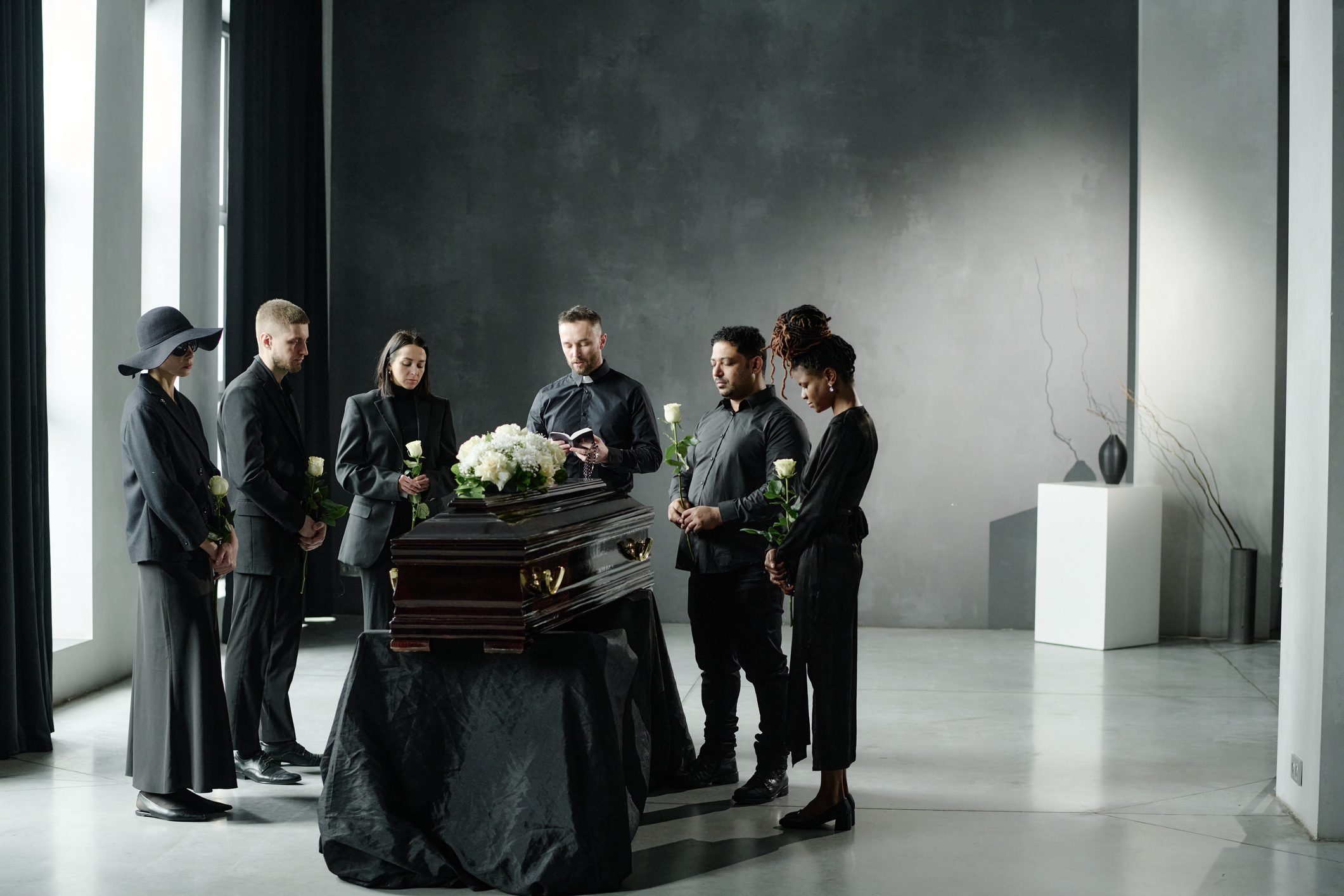 People gathered around a casket at funeral.