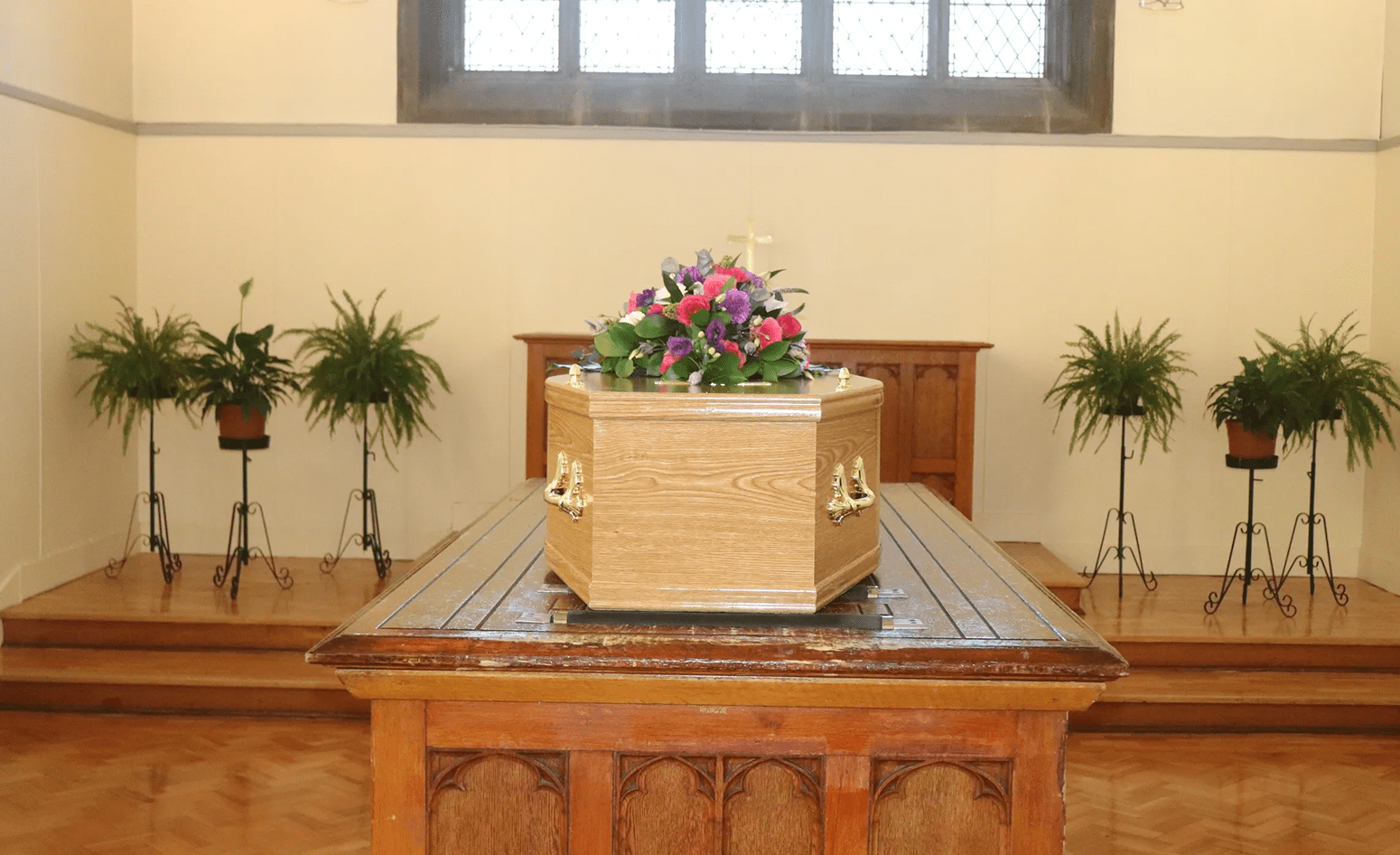 Coffin with flowers in a chapel.